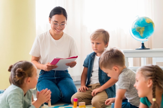 Kostenloses Foto kindergärtnerin hält ein notizbuch