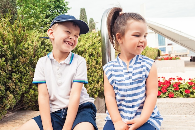 Kostenloses Foto kindermode-konzept. jugendlich junge und mädchen, die am park sitzen