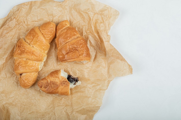 Kostenloses Foto köstliche frische zwei croissants auf einem pergamentpapier.