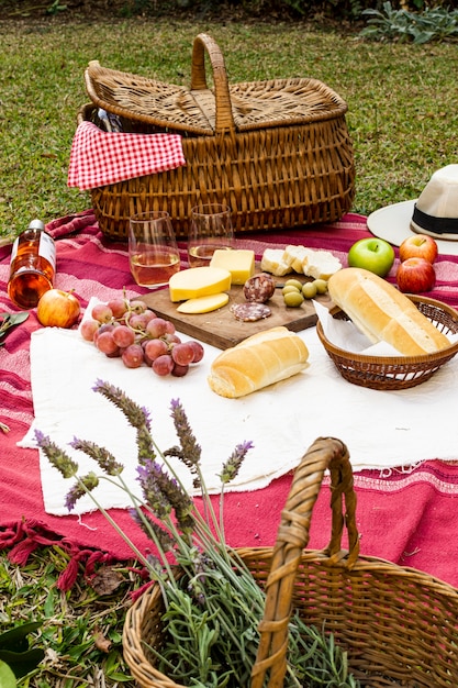 Kostenloses Foto korb mit lavendel neben picknick-leckereien