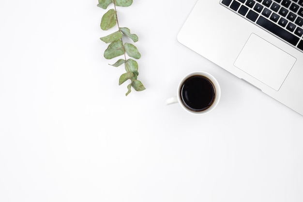 Kostenloses Foto laptop und eine tasse schwarzen kaffee auf weißem hintergrund, draufsicht