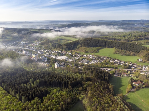 Kostenloses Foto luftbildaufnahme von schönen grünen feldern und häusern der landschaft an einem sonnigen tag