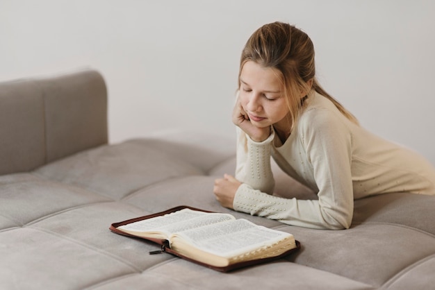 Kostenloses Foto mädchen, das ein heiliges buch studiert