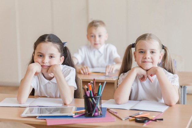 Mädchen, die am Schreibtisch im Klassenzimmer sitzen