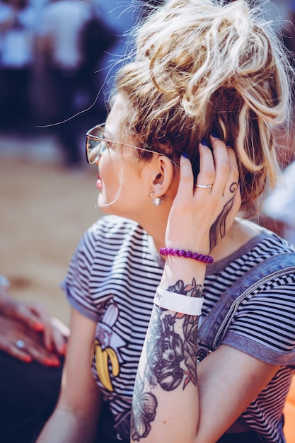 Kostenloses Foto mädchen in vintage sonnenbrille mit tattoos porträt nahaufnahme auf der straße während eines picknicks mit freunden. chill-mädchen