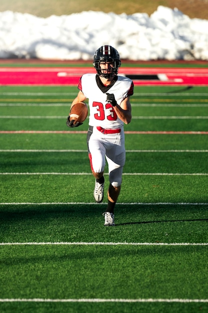 Kostenloses Foto männlicher amerikanischer fußballspieler in uniform auf dem feld