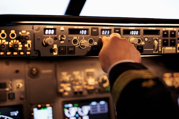 Kostenloses Foto männlicher kapitän, der höhen- und längengrad auf dem armaturenbrett im flugzeugcockpit festlegt. pilot drückt tasten auf dem bedienfeldschalter und verwendet die windschutzscheibe in der flugzeugkabine, um das flugzeug zu fliegen. nahansicht.