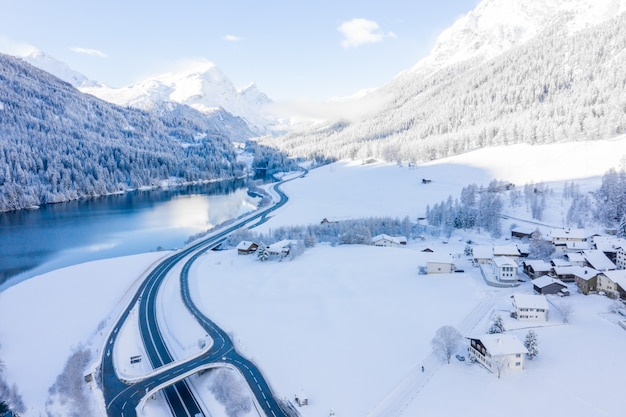 Kostenloses Foto magischer schweizer wintersee im zentrum der alpen, umgeben von schneebedecktem wald