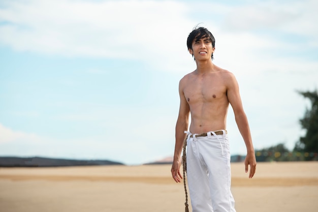 Kostenloses Foto mann am strand, der alleine capoeira übt