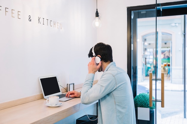 Mann, der am Laptop im Café arbeitet