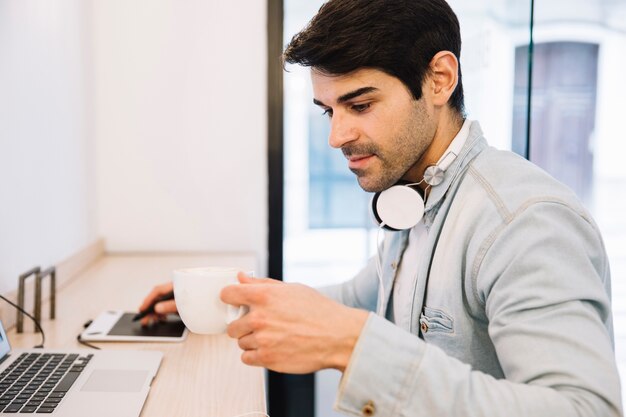 Mann, der an dem Computer hält Schale arbeitet