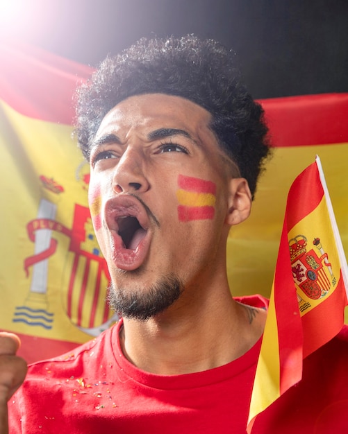 Kostenloses Foto mann jubelt und hält die spanische flagge