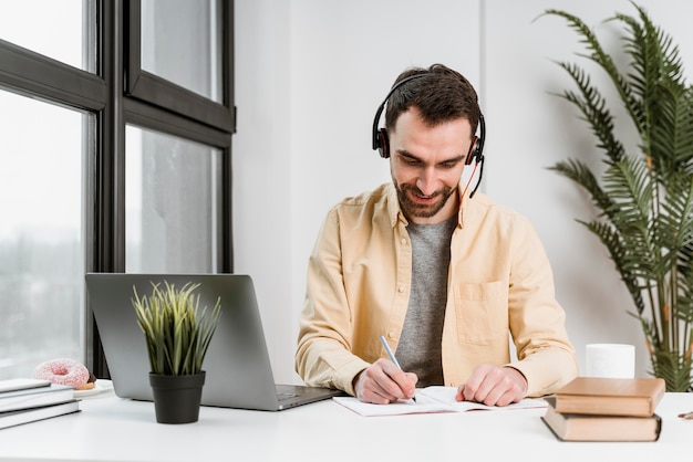 Mann mit Headset, der Videoanruf auf Laptop hat