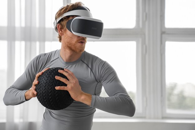 Mittelgroßer Mann beim Fitnesstraining mit VR-Brille