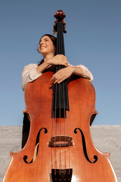 Mittelstarke Smiley-Frau mit Instrument