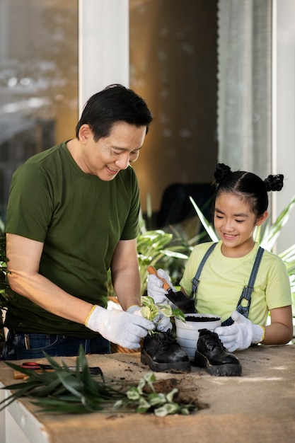 Kostenloses Foto mittlere schussleute, die mit alten schuhen im garten arbeiten