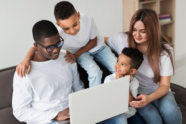 Multikulturelle Familie, die zusammen auf einem Laptop schaut