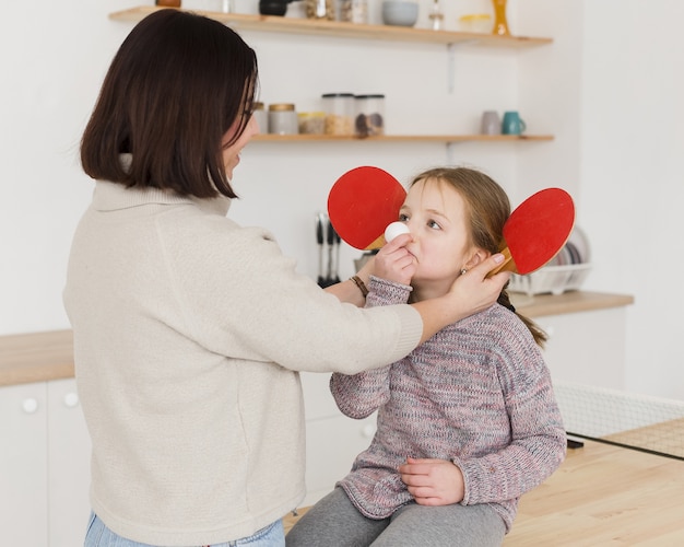 Mutter, die mit entzückender Tochter verspielt ist