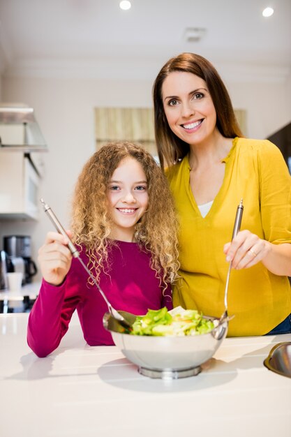 Mutter Unterstützung Tochter Salat bei der Herstellung von