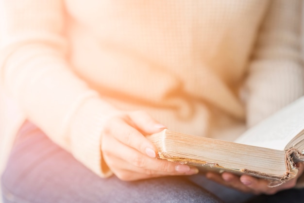 Kostenloses Foto nahaufnahme der hand der frau, die buch in der hand hält