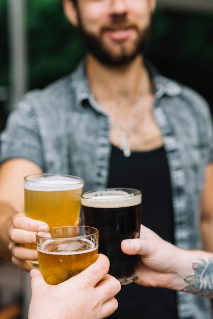 Kostenlose Foto nahaufnahme des mannes die gläser bier mit seinen freunden zujubelnd