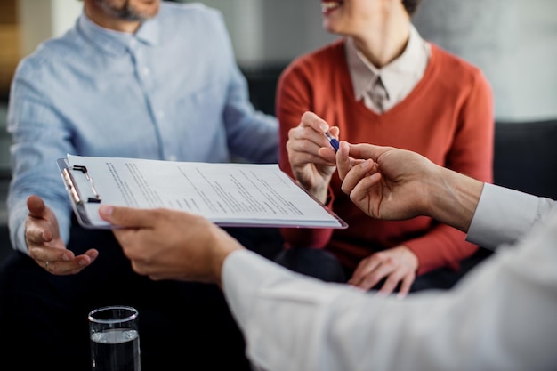 Kostenloses Foto nahaufnahme eines nicht erkennbaren paares, das einen vertrag mit einem finanzberater unterzeichnet