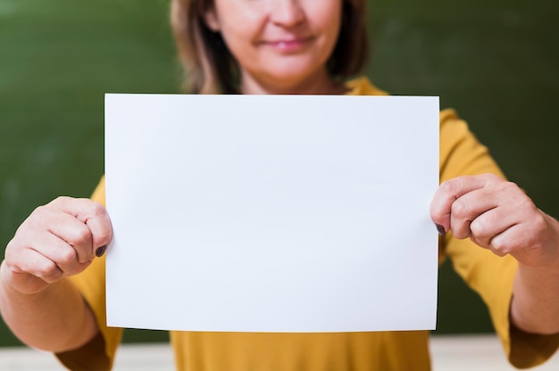 Kostenloses Foto nahaufnahme lehrer, der leeres papierblatt hält