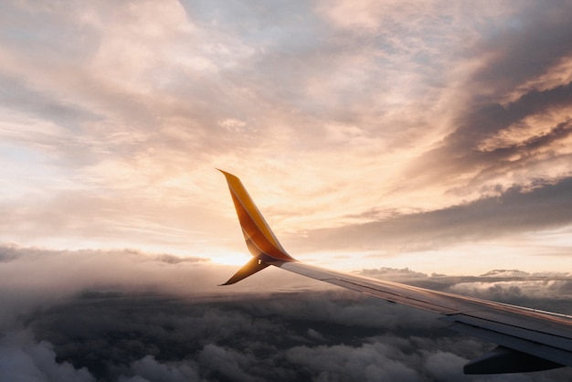 Kostenloses Foto nahaufnahmeaufnahme eines flugzeugflügels in einem rosa himmel