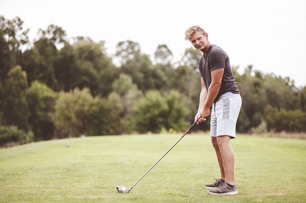 Kostenlose Foto nahaufnahmefokusporträt eines jungen mannes, der golf spielt