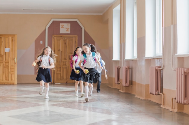 Kostenloses Foto nette kinder, die in schulkorridor laufen