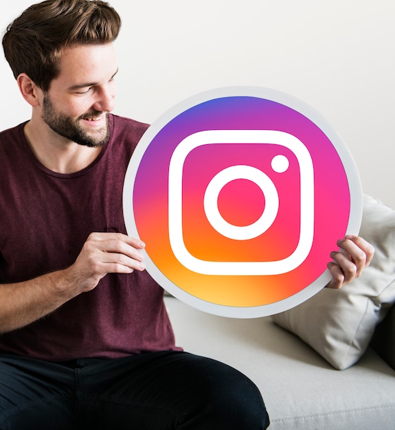 Kostenloses Foto netter mann, der eine instagram-ikone anhält