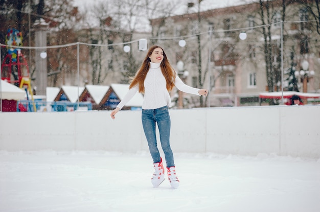 Kostenloses Foto nettes und schönes mädchen in einer weißen strickjacke in einer winterstadt