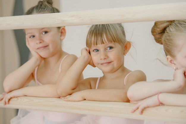 Kostenloses Foto niedliche kleine ballerinas im rosa ballettkostüm. kinder in spitzenschuhen tanzen im raum. kind im tanzkurs.