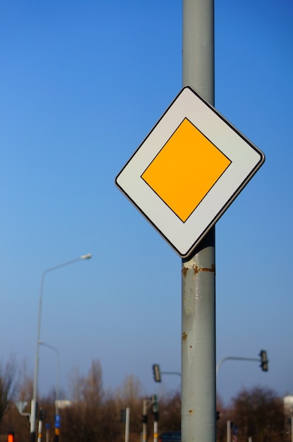 Kostenloses Foto niedriger winkelschuss eines vorrangigen verkehrszeichens unter einem klaren blauen himmel