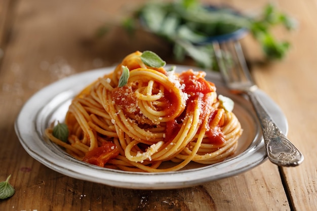 Kostenloses Foto pasta-spaghetti mit tomatensauce und käse auf teller serviert