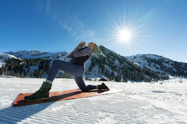 Kostenloses Foto person, die bei kaltem und winterlichem wetter yoga macht