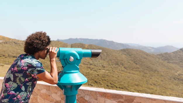 Kostenloses Foto person, die landschaft durch fernglas betrachtet