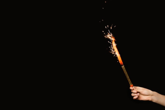 Kostenloses Foto personenhand mit loderndem feuerwerk