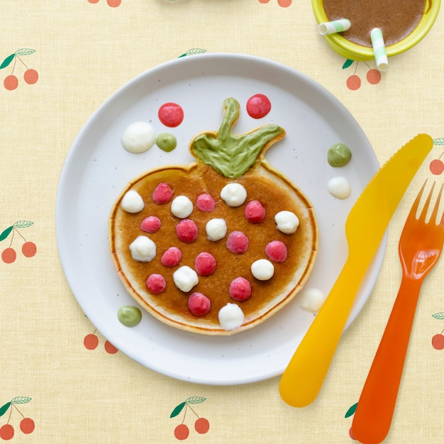 Kostenlose Foto pfannkuchen-frühstücksleckerbissen für kinder in form einer lustigen erdbeere