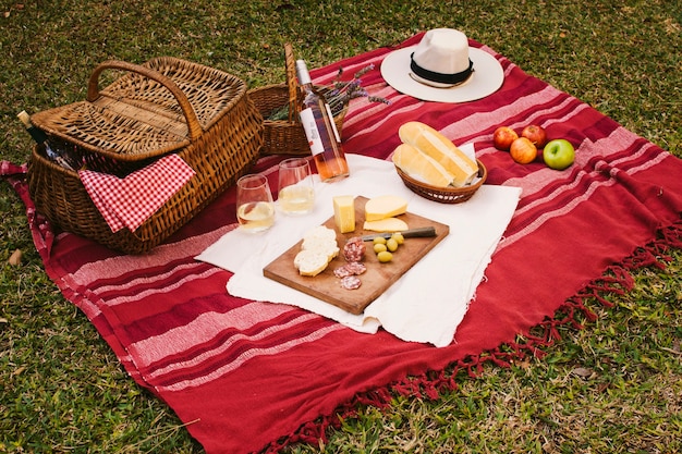 Kostenloses Foto picknickkorb mit guten sachen auf roter decke