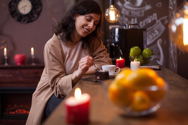 Porträt einer attraktiven jungen kaukasischen Frau, die Kuchen an der Theke in einem Hipster-Café isst. Schöne Frau, die leckeren Kuchen in einem Café isst.