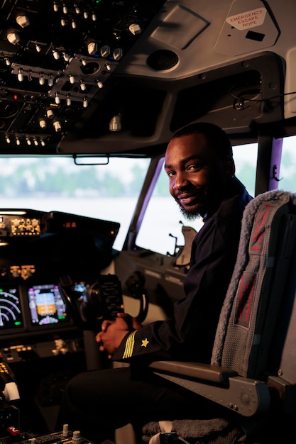 Kostenloses Foto porträt eines männlichen fliegers, der flugbereit im flugzeugcockpit sitzt und die navigation auf dem bedienfeld und die befehlstasten des dashboards verwendet. pilot fliegendes flugzeug mit windschutzscheibe, kompass und radar.