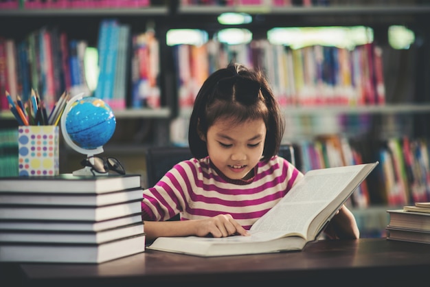 Kostenloses Foto porträt eines studentenkindermädchens, das an der bibliothek studiert