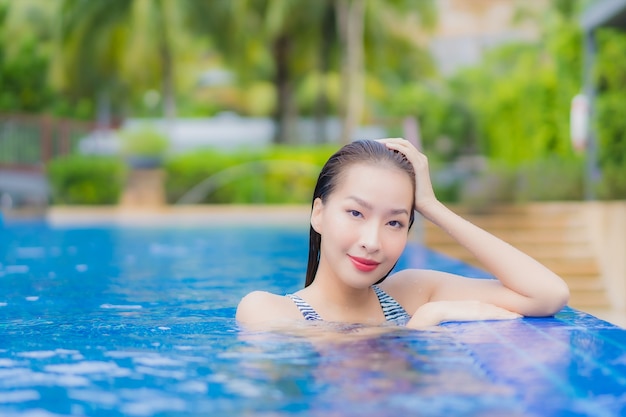 Kostenlose Foto porträt schöne junge asiatische frau entspannen lächeln freizeit um freibad im hotel resort auf urlaubsreise