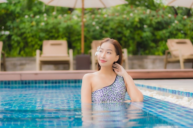 Kostenlose Foto porträt schöne junge asiatische frau im freien im schwimmbad in urlaubsreise entspannen