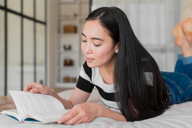 Porträtfrau im Bett lesen