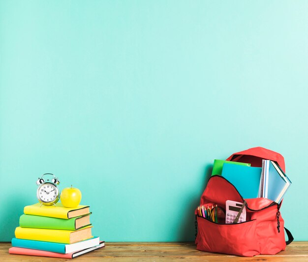 Rucksack und Lehrbücher auf dem Schreibtisch