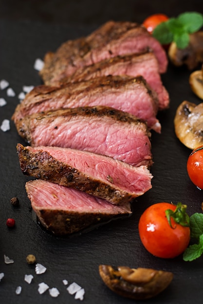 Kostenloses Foto saftiges steak mittleres seltenes rindfleisch mit gewürzen und gegrilltem gemüse.