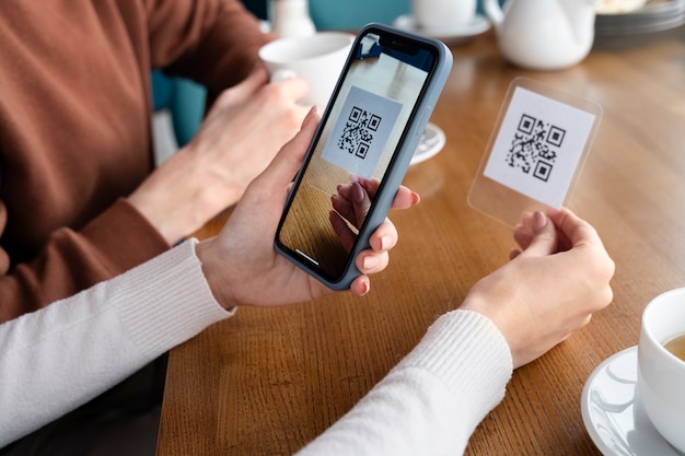 Kostenloses Foto schließen sie die hände, die den qr-code scannen