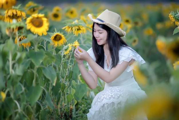 Kostenloses Foto schöne sexy frau in einem weißen kleid auf einem feld von sonnenblumen, gesunder lebensstil